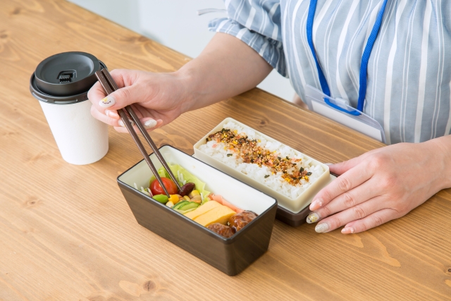 会社の机でお弁当を食べる女性